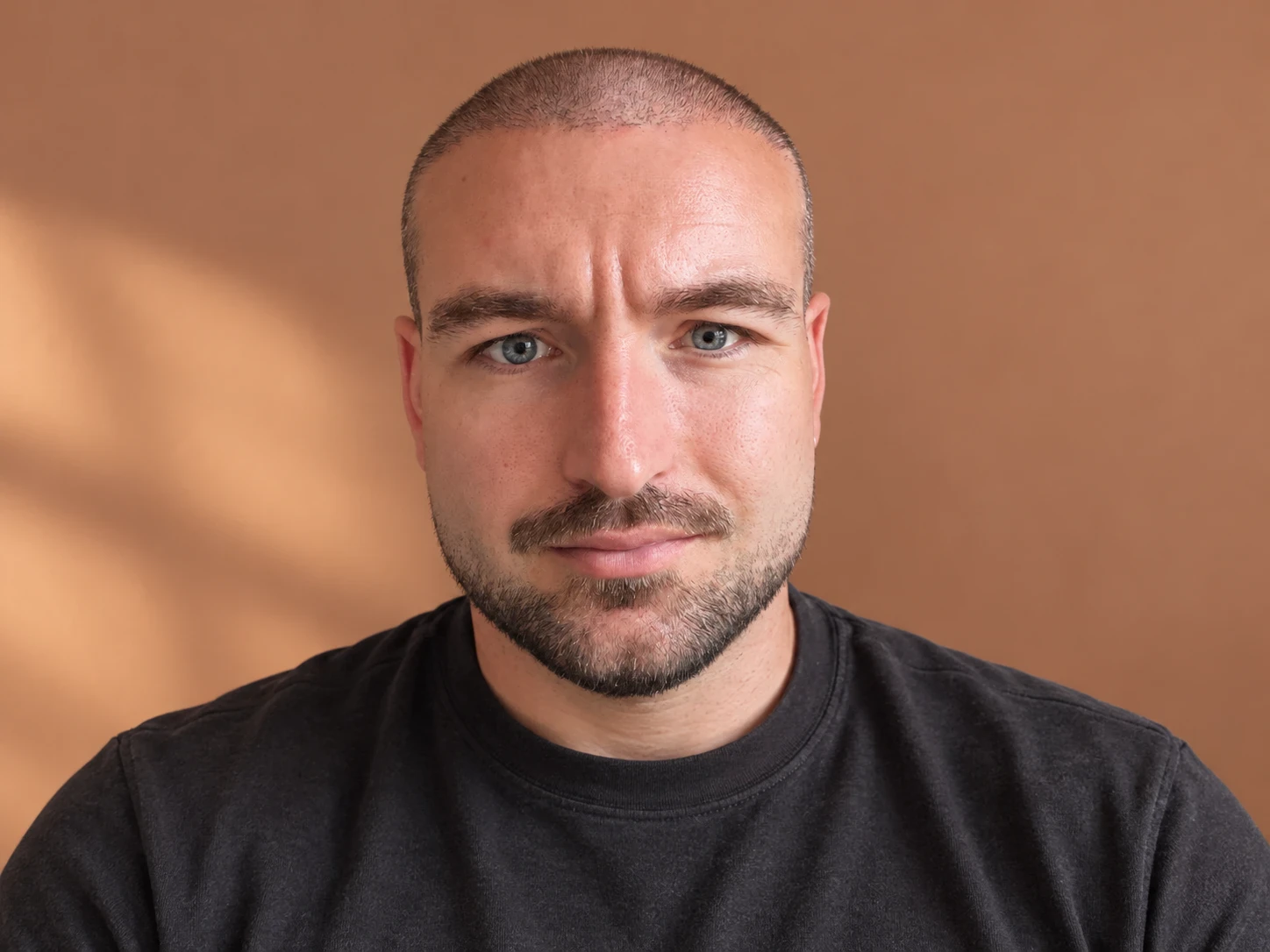 Man met een buzz cut en een korte, verzorgde baard, recht van voren gezien
